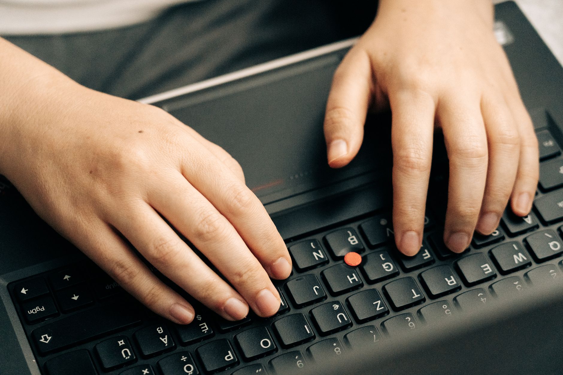 Hände tippen auf einer Tastatur, daneben ein ausgefülltes Formular