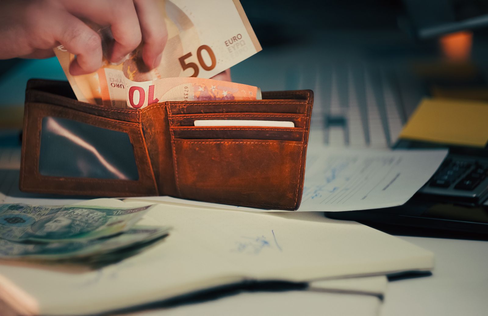Geldbörse mit Euroscheinen auf Unterlagen am Schreibtisch