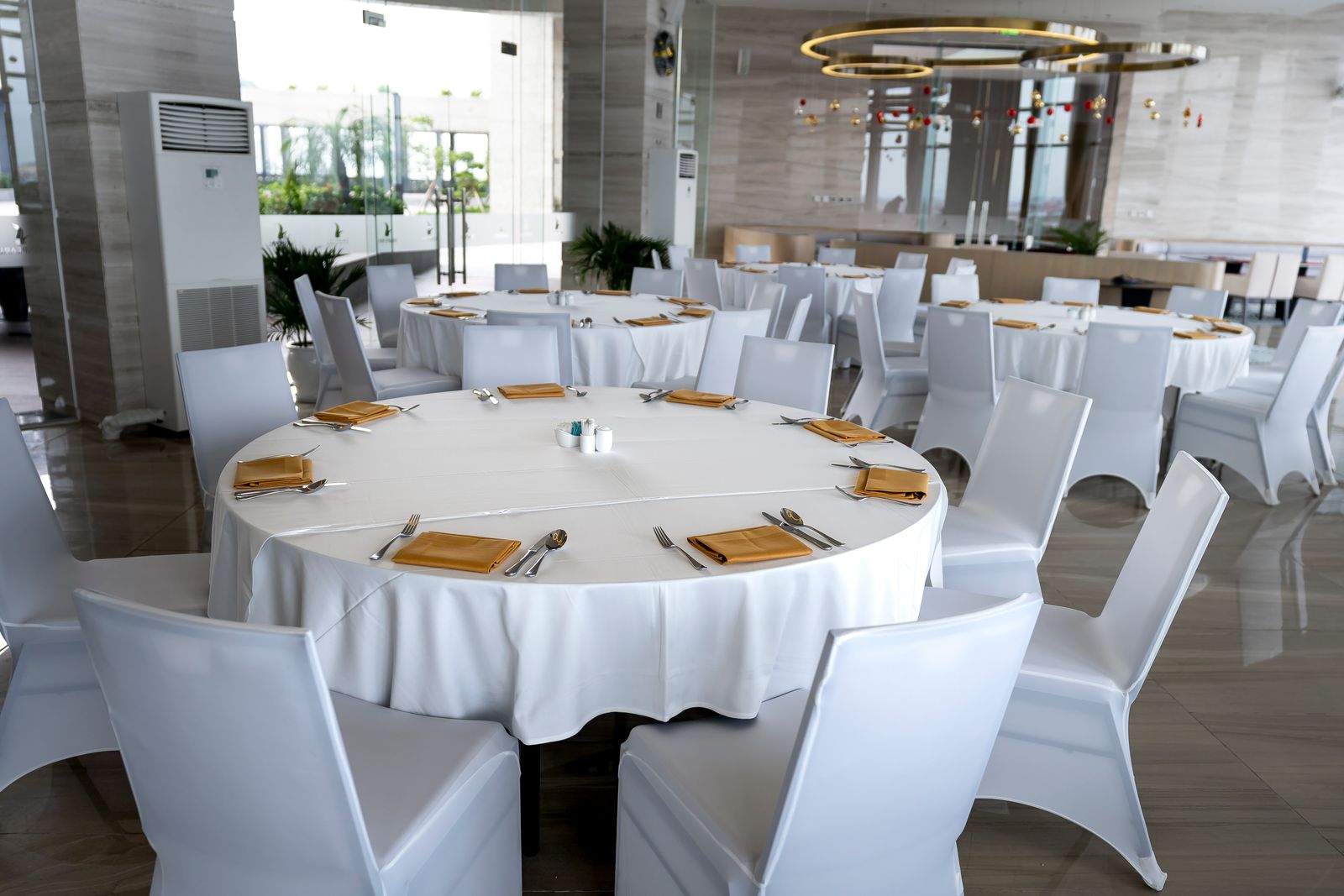 Leerer Saal mit eingedeckten runden Tischen