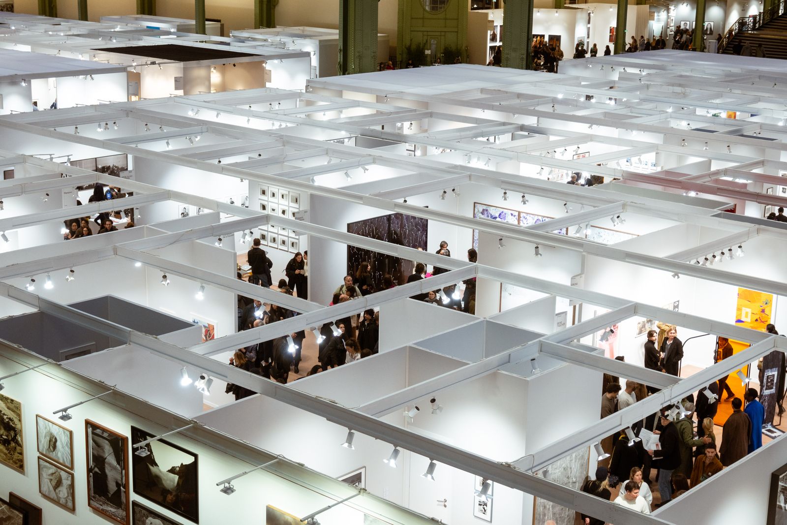 Blick von oben auf weiße Standkojen einer Ausstellung mit Besuchern