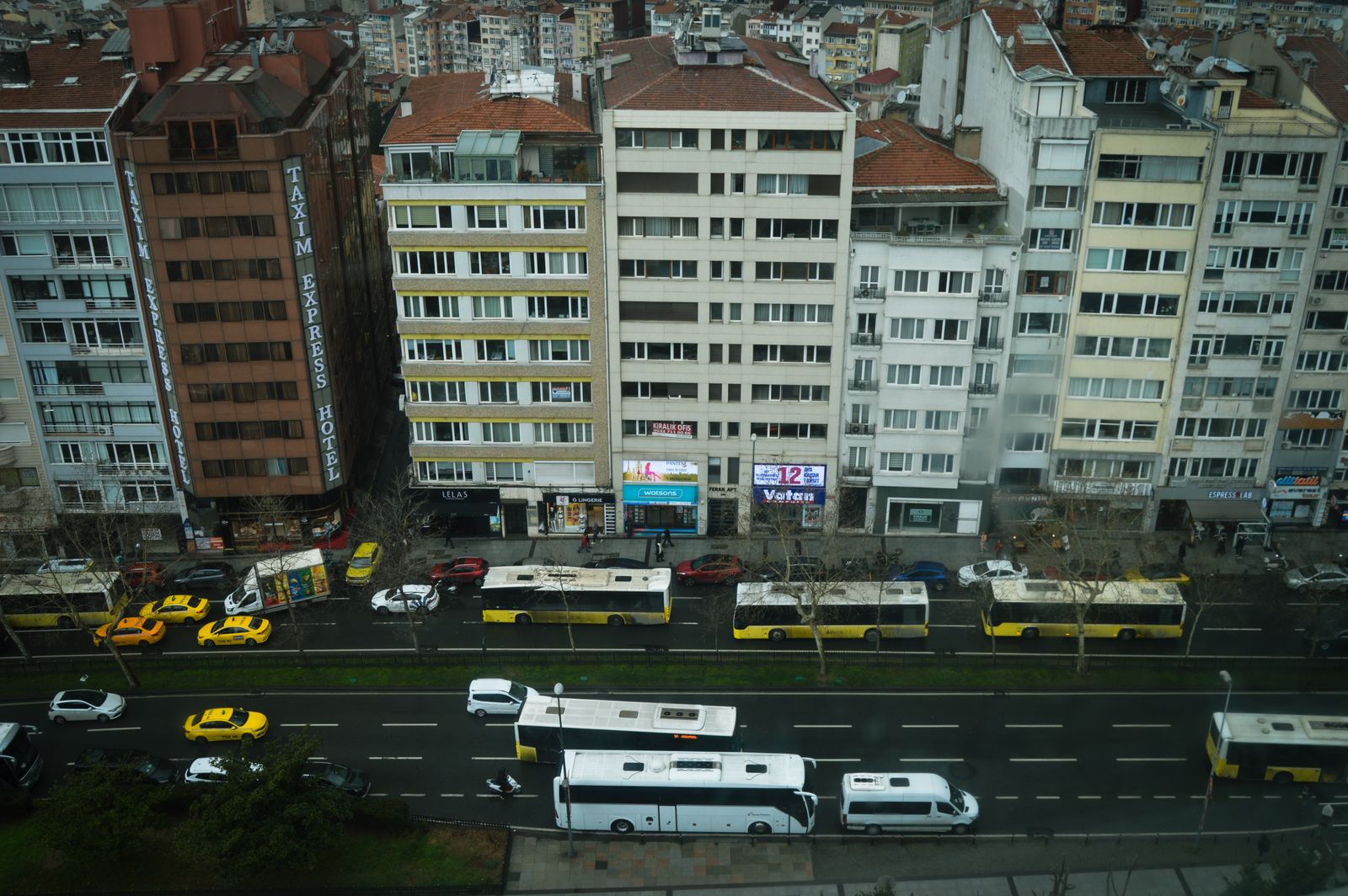 Luftaufnahme einer Stadtstraße mit Bussen und Wohnhäusern