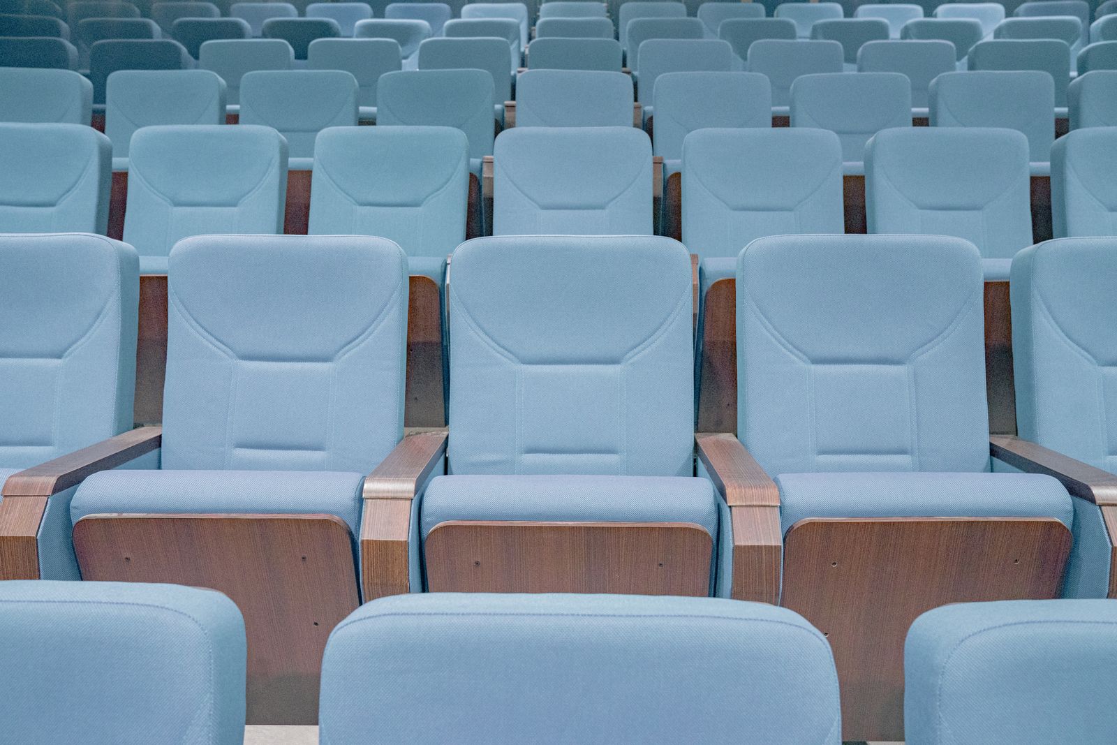 Reihen leerer blauer Sitze in einem Saal