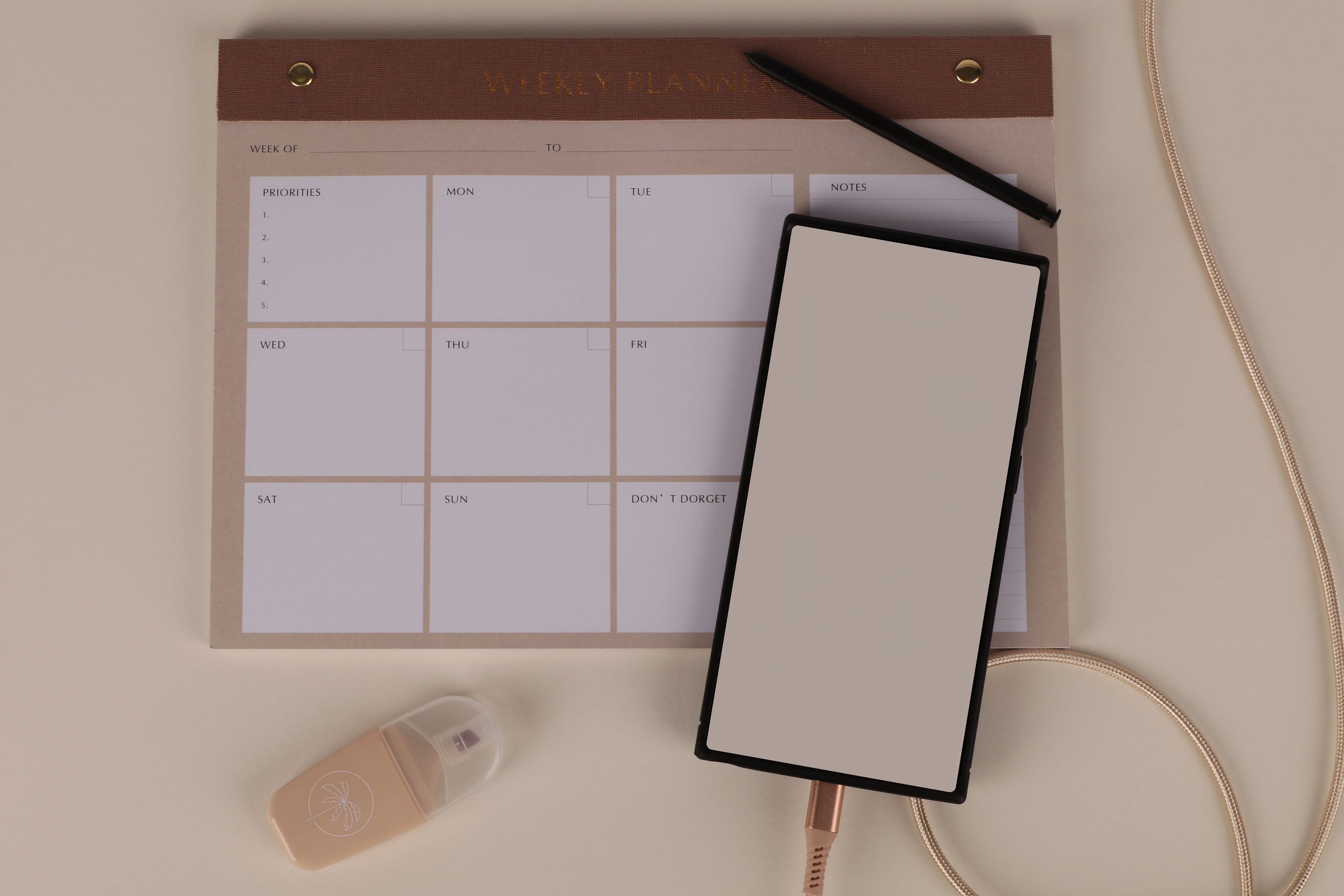 Wochenplaner, Smartphone und Stift auf einem Schreibtisch