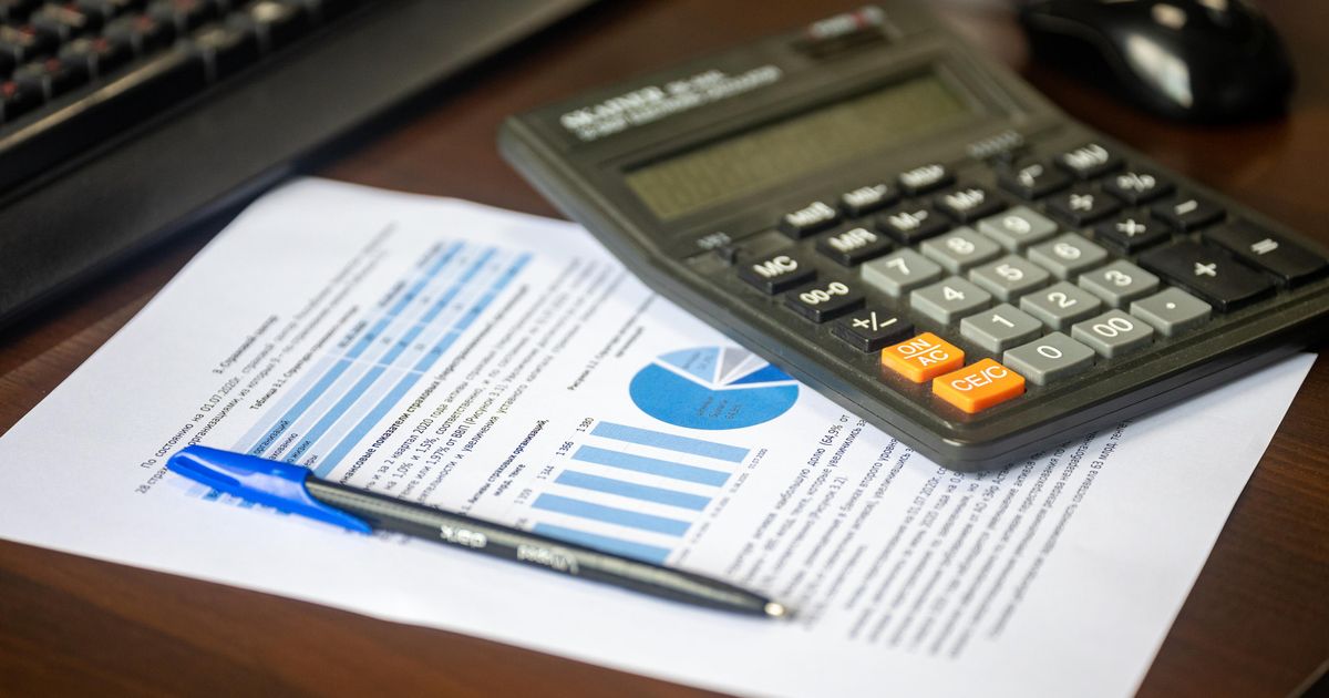 Taschenrechner, Finanzbericht und Stift auf einem Schreibtisch