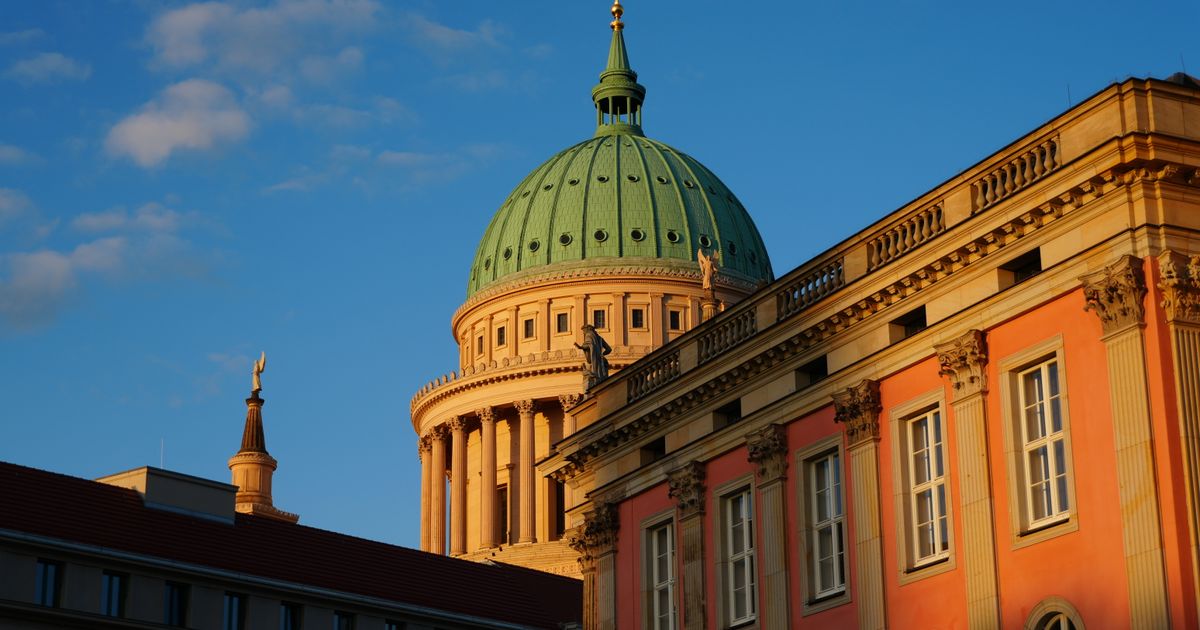 Kuppel der Nikolaikirche in Potsdam neben dem Landtagsgebäude unter blauem Himmel