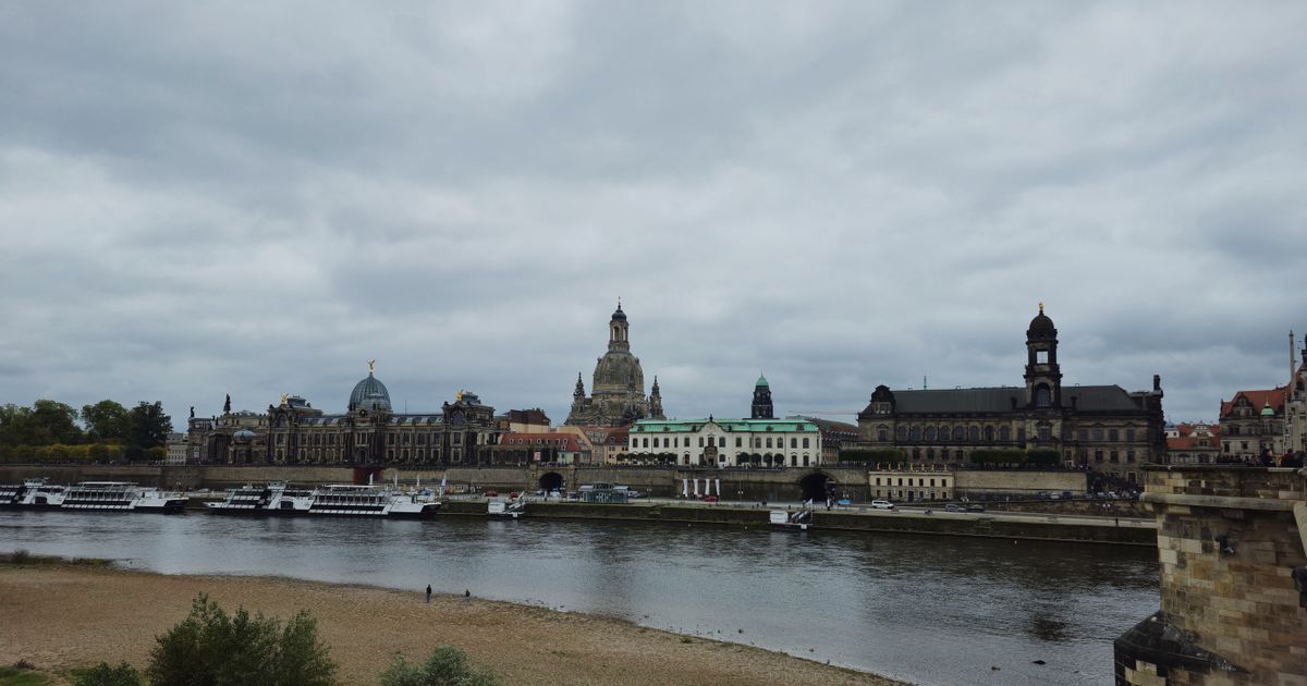 Altstadt von Dresden an der Elbe mit Frauenkirche und Hausmannsturm unter bewölktem Himmel