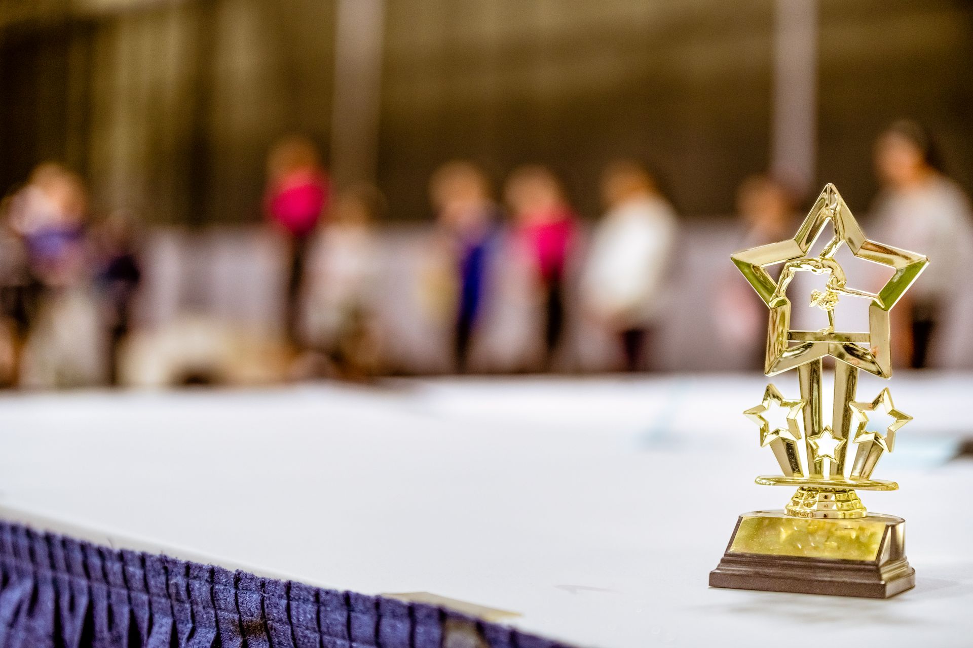 Goldene Sterntrophäe auf einem Tisch vor unscharfem Publikum