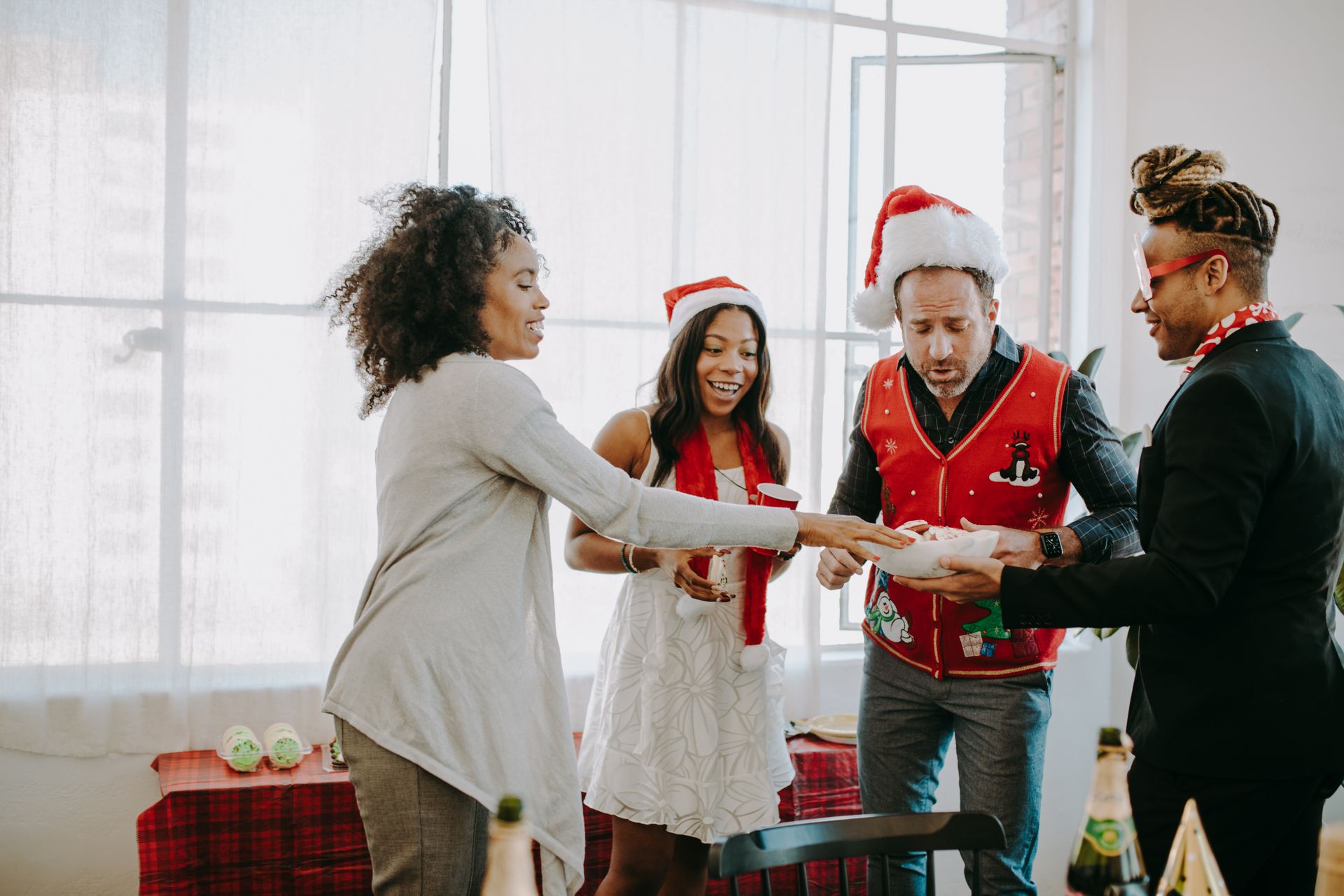 Kolleginnen und Kollegen tauschen auf einer Weihnachtsfeier im Büro Geschenke aus