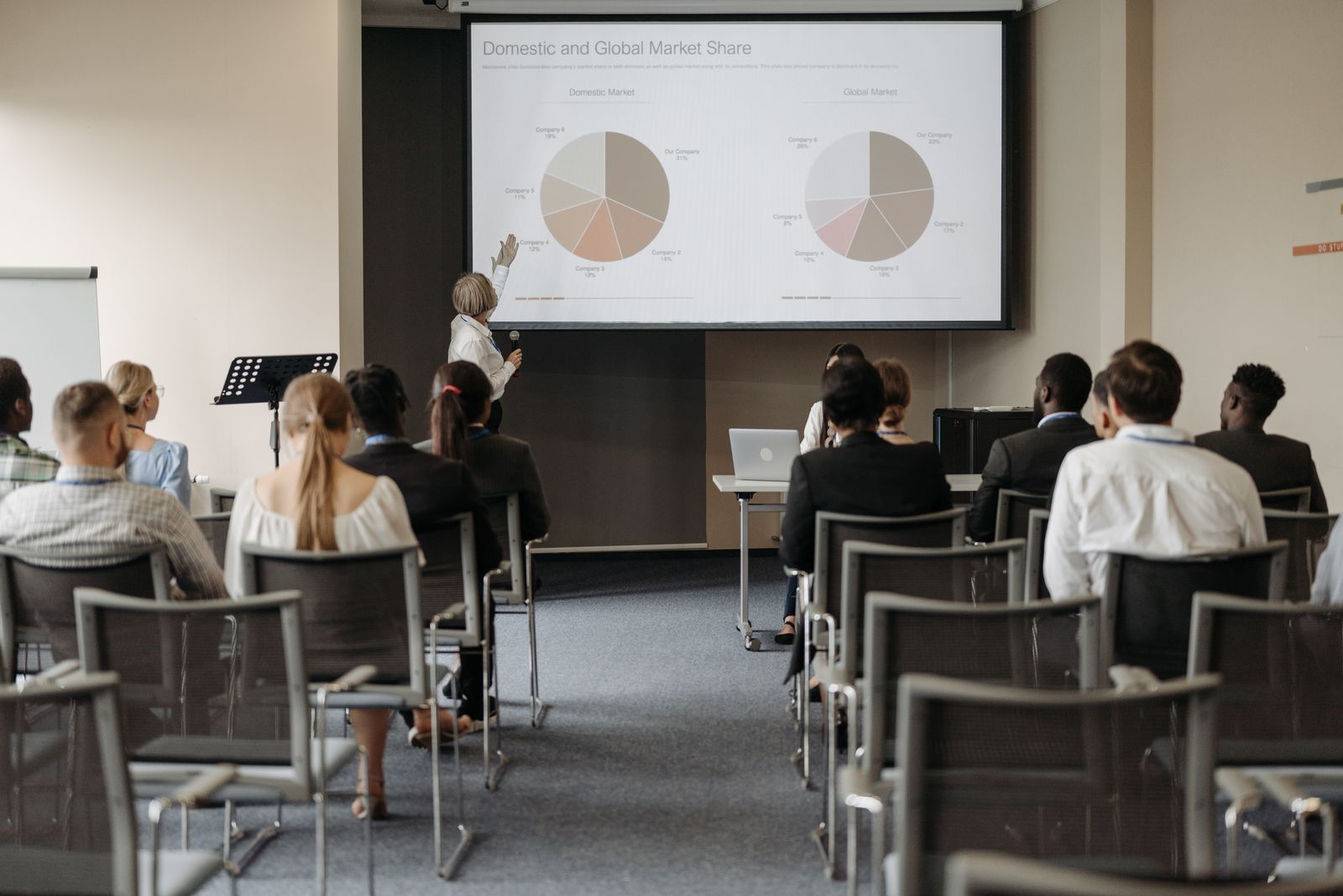 Konferenzpublikum vor einer Leinwand mit einem Diagramm