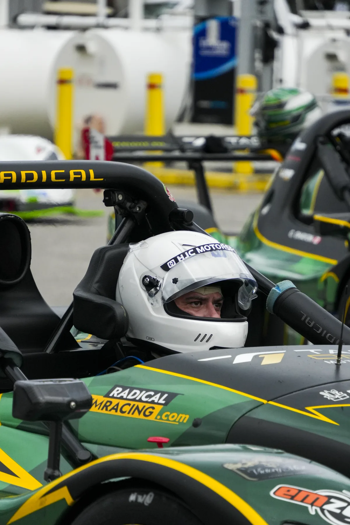 Pilote Tag One casqué dans le cockpit de sa Radical SR3 XXR