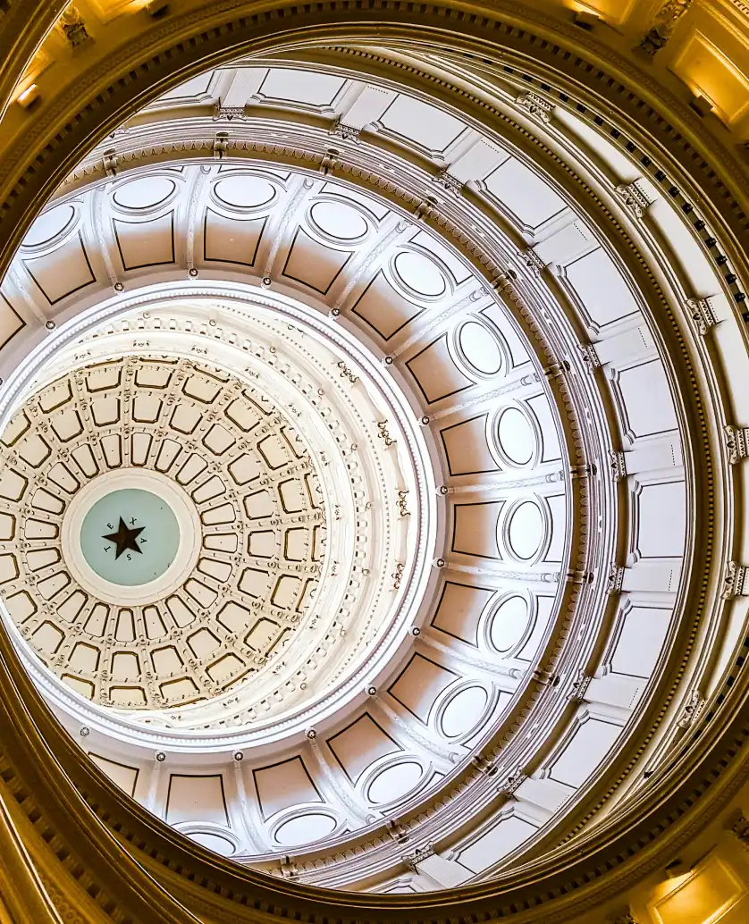 Interior view looking up into a domed ceiling with concentric rings and a star at the center.