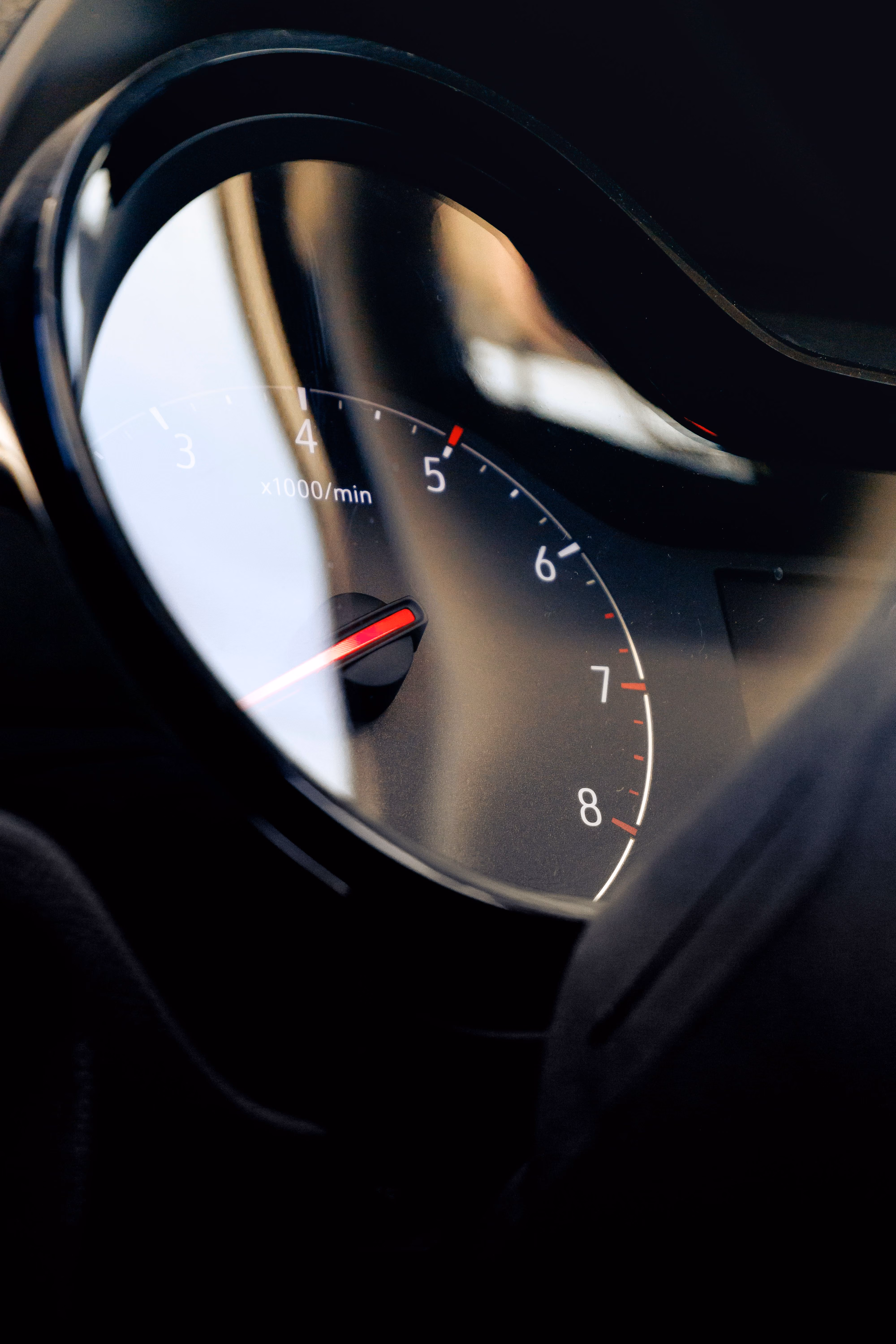 Close-up of a car tachometer showing around 1,000 revolutions per minute.