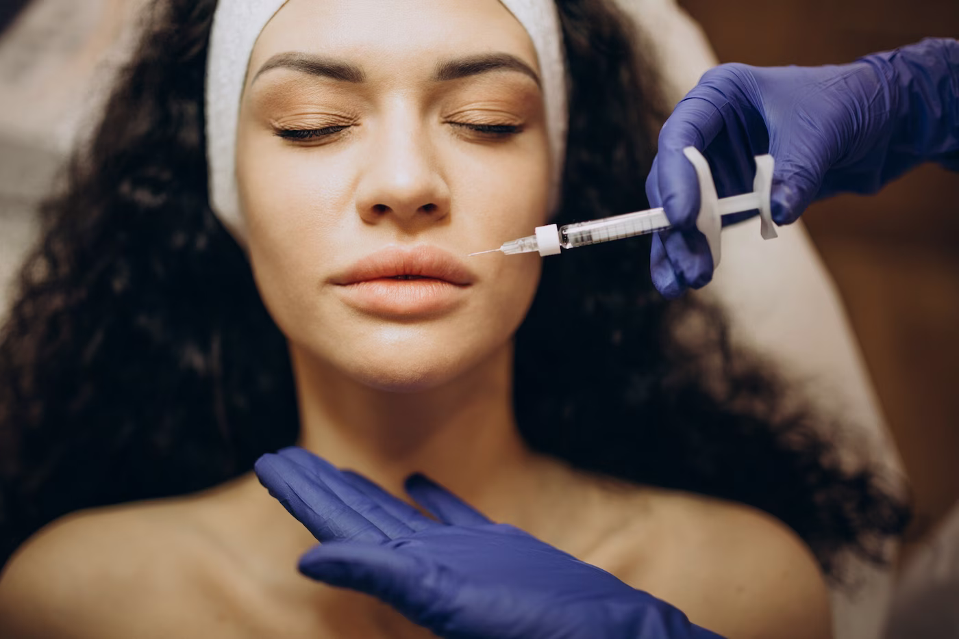 Nurse injector performing a lip filler treatment at Aesthetics Collective med spa in Murfreesboro, TN