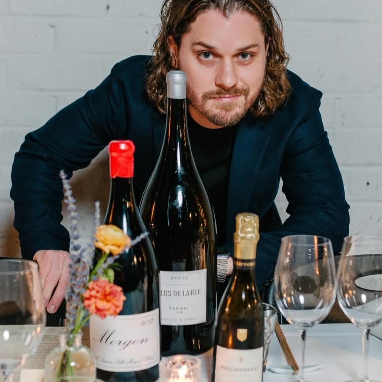 Ian Krupp, Wine Director at Anajak Thai, with bottles of Morgon, Clos de la Rue Saumur, and Philipponnat