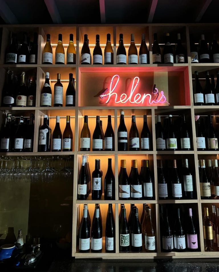 Helen's Wines bottle display with glowing pink neon sign at Jon & Vinny's Fairfax in Los Angeles