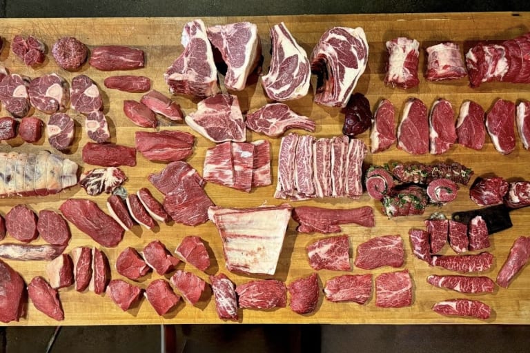 Whole-animal breakdown laid out on the cutting block at Beast & Cleaver