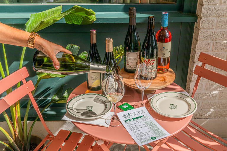 A wine pour at Montrose Cheese & Wine's outdoor table setting