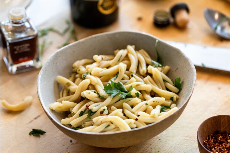 A bowl of Ferrazzani's fresh casarecce pasta tossed with parsley, olive oil, and chili flakes