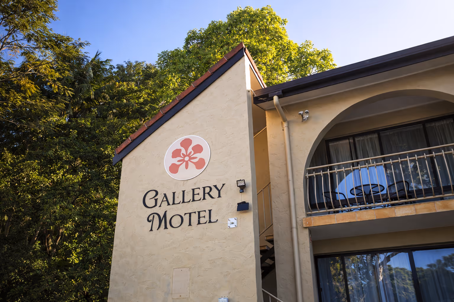 Gallery Motel exterior — Mediterranean-style boutique motel surrounded by lush Tweed Valley greenery in South Murwillumbah