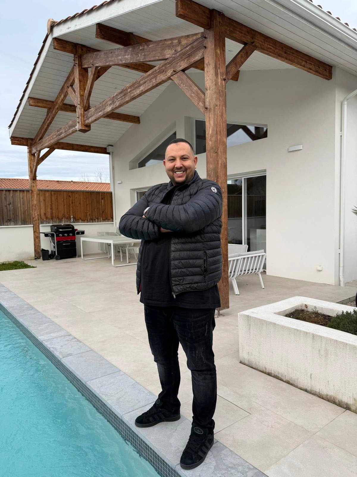 alt="Nourredine Bouakkaoui gérant de Bati'Art Construction entreprise de rénovation à Bordeaux devant une maison rénovée"