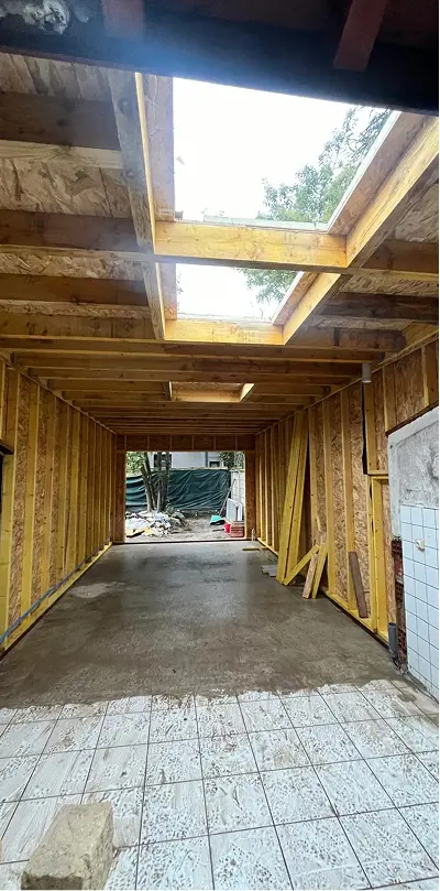 alt="chantier d’extension de maison avec ossature bois, charpente apparente et dalle béton en cours de travaux à Bordeaux"