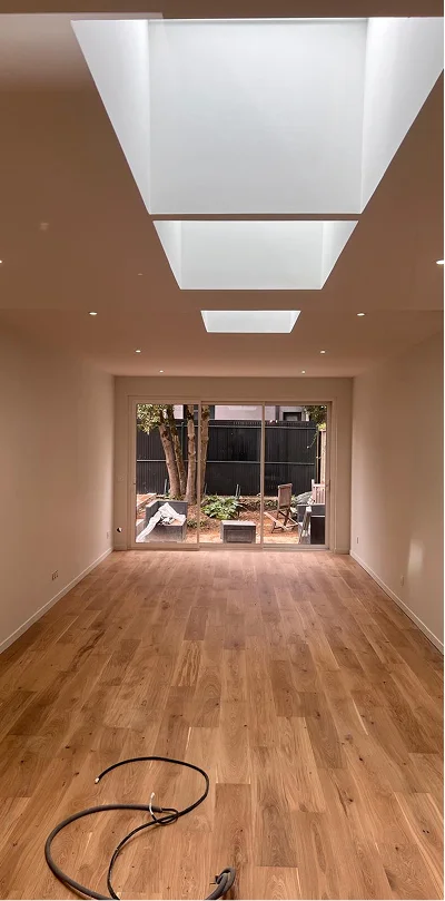 alt="agrandissement de maison avec nouvelle pièce de vie lumineuse, parquet bois et grande baie vitrée réalisé à Bordeaux"