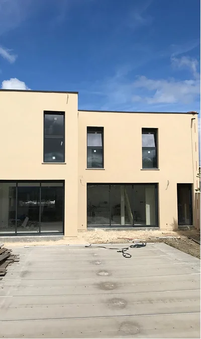 alt="maison rénovée avec façade enduite et menuiseries gris anthracite après travaux de rénovation à Bordeaux"