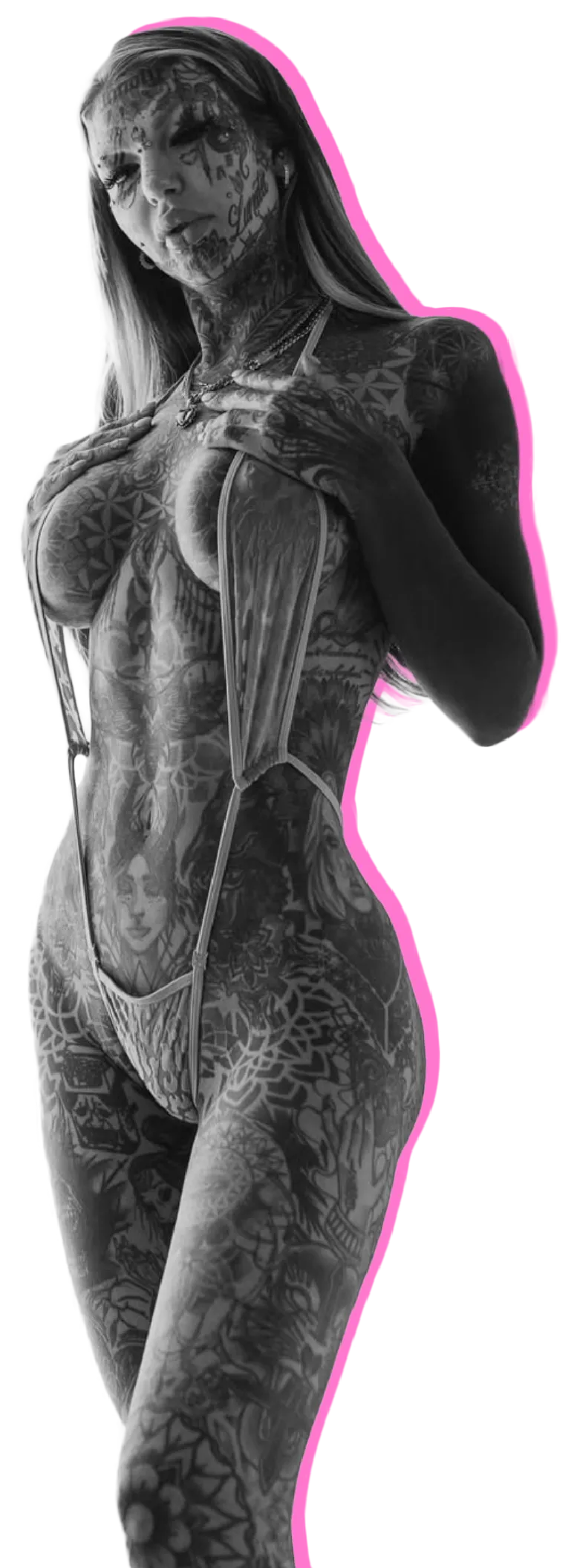 Tattooed woman wearing minimal lingerie with long hair and multiple facial and body tattoos.