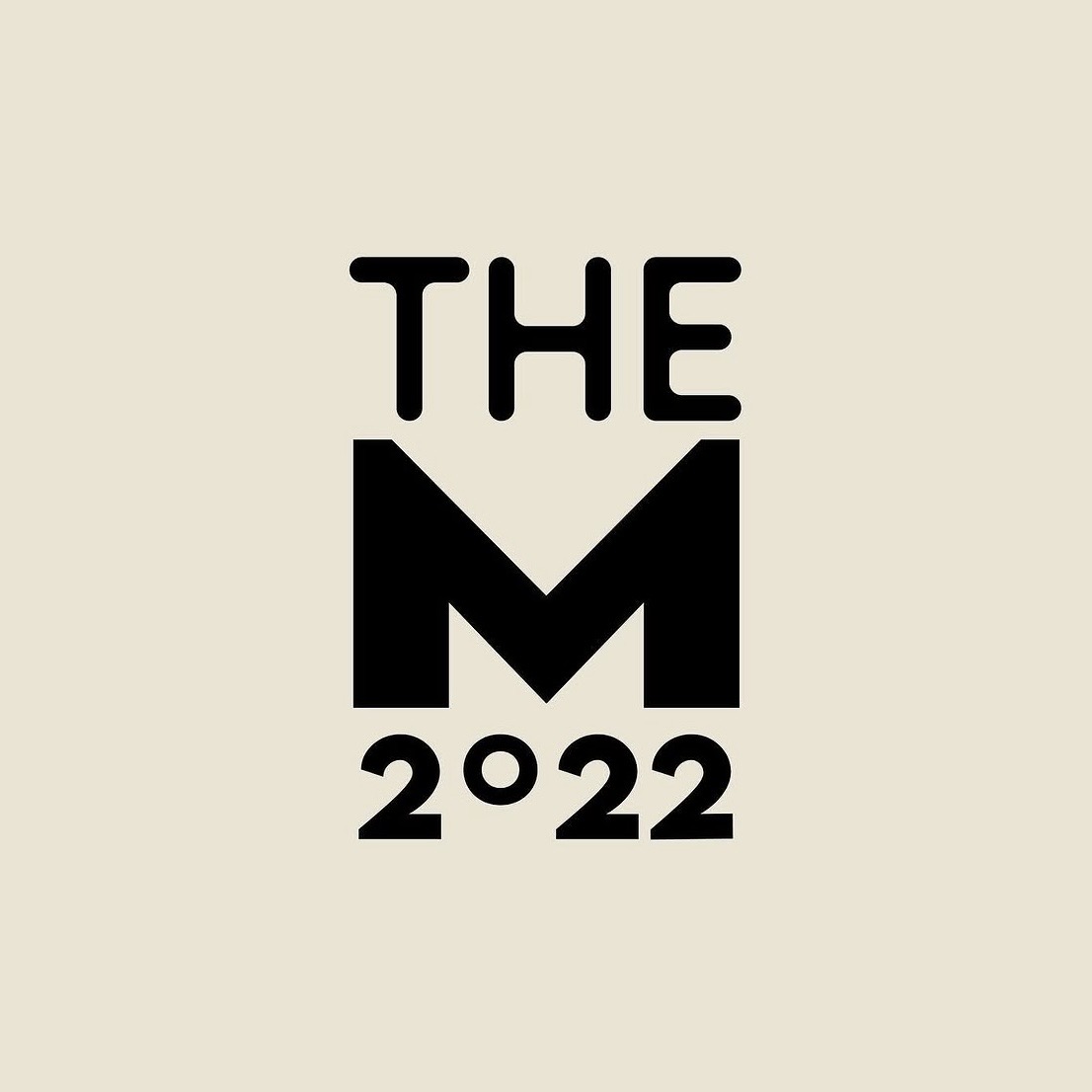 Black text logo reading 'THE M 2022' on a beige background.