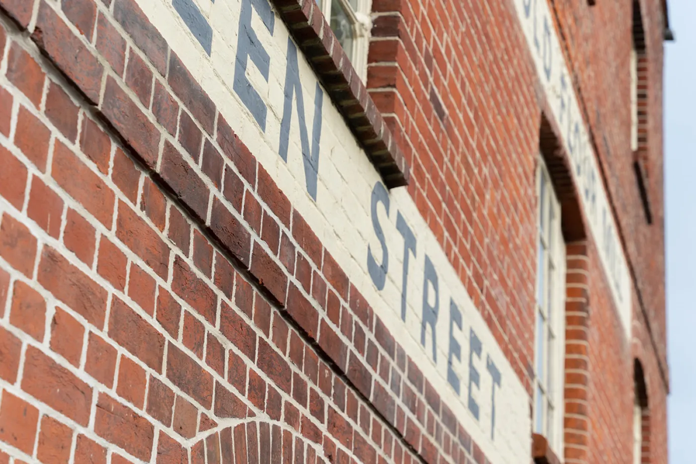 Red brick building with a painted street name sign reading 'STREET' on a white background.