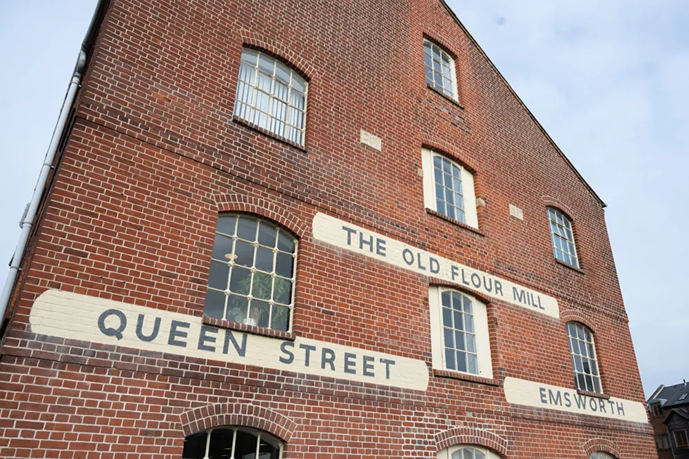 Close-up of a red brick building with white signs painted on it, one reading 'STREET'.
