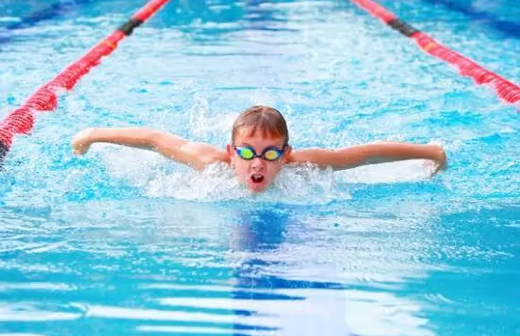 Students swimming freestyle in adjacent lanes at a school swimming carnival