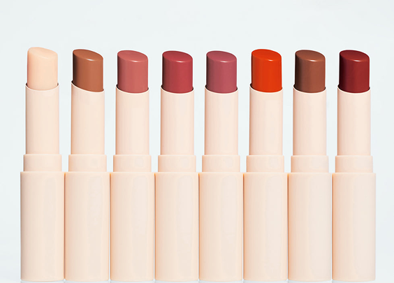 Eight lipsticks in varying shades from nude to deep red, displayed in a row with beige casings.