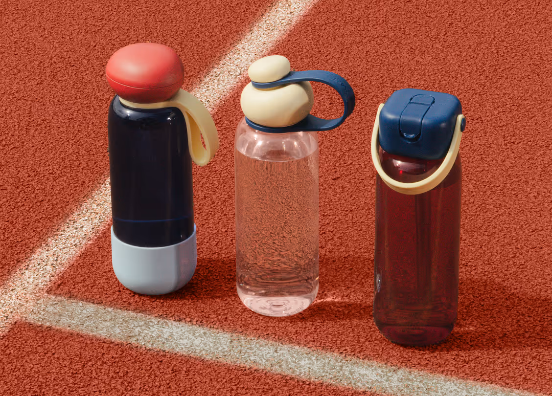 Three Sunnies Flask tumblers with distinct caps standing on a red textured surface with white lines.