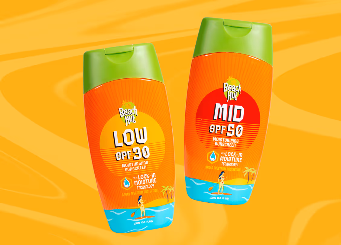 Two bottles of Beach Hut moisturizing sunscreen with SPF 30 and SPF 50, featuring lock-in moisture technology and tropical beach design.