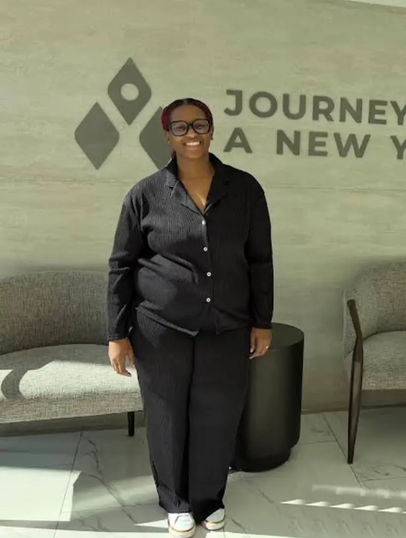 Dr. Sandy Martinez standing with a smiling patient shortly after bariatric surgery. A thumbs-up celebrating a safe and quick recovery in a modern medical setting.