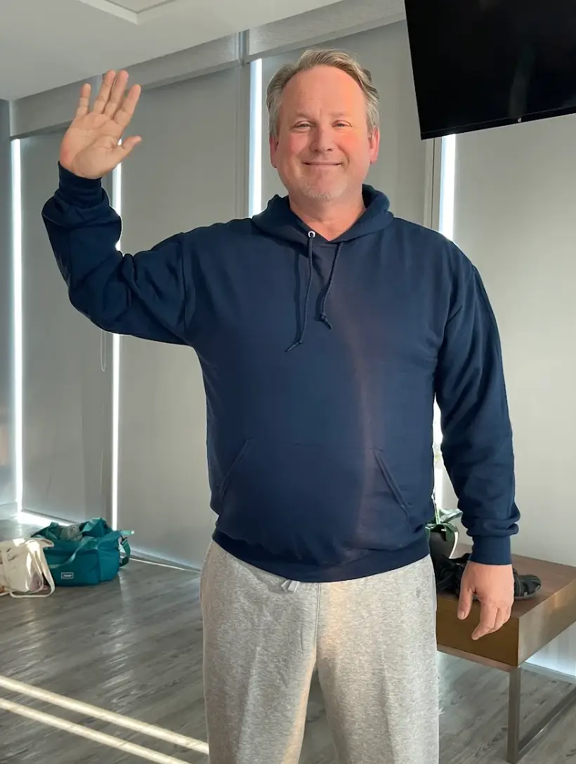 Dr. Sandy Martinez standing with a smiling patient shortly after bariatric surgery. A thumbs-up celebrating a safe and quick recovery in a modern medical setting.