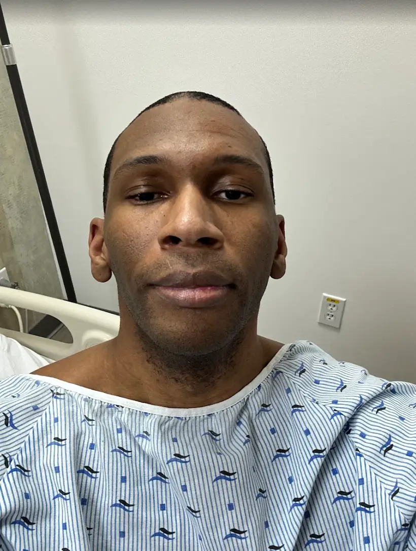 Dr. Sandy Martinez standing with a smiling patient shortly after bariatric surgery. A thumbs-up celebrating a safe and quick recovery in a modern medical setting.