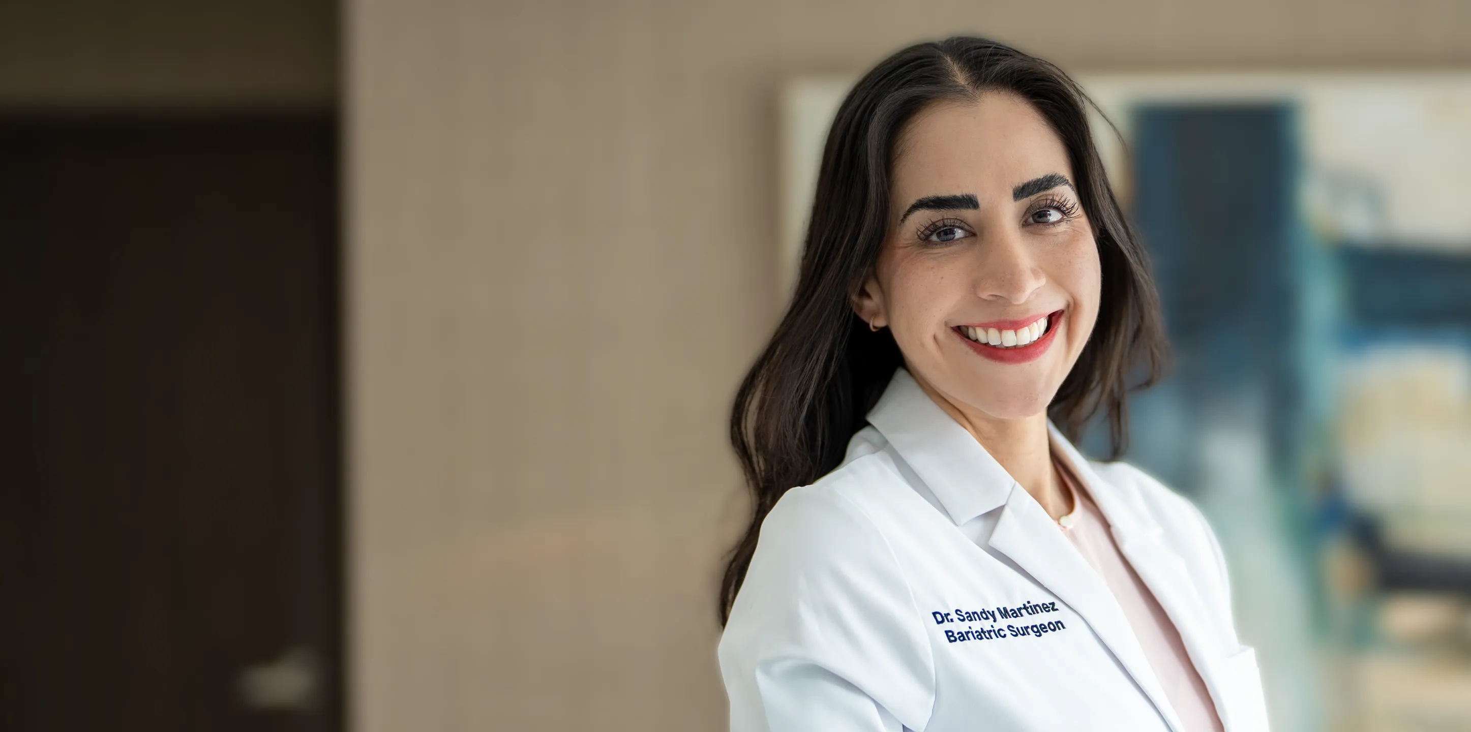 Dr. Sandy Martinez, certified female bariatric surgeon, smiling in a white medical coat at her professional weight loss clinic.