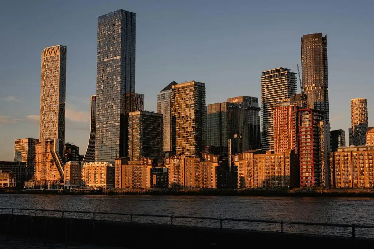 Canary Wharf skyline featuring tall financial buildings and a body of water, symbolizing the UK's economic job sector.