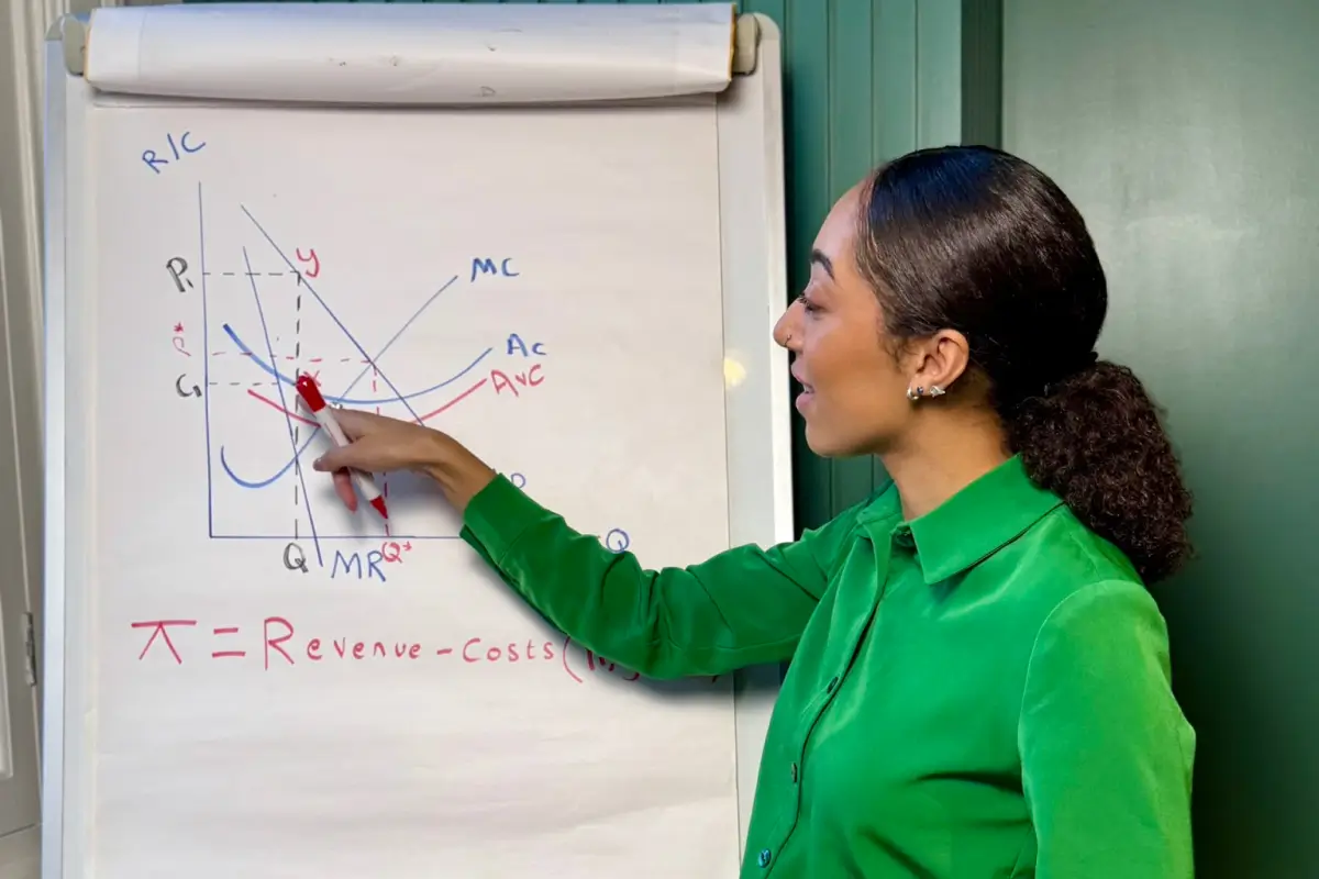 Asha Wadley, an economics tutor, explains a diagram on a whiteboard during an online tuition class.