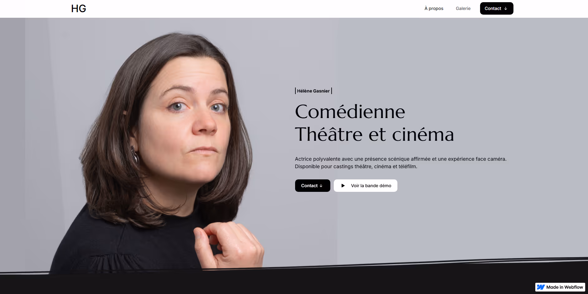 Portrait d’une femme aux cheveux bruns regardant vers la droite sur fond gris pâle.