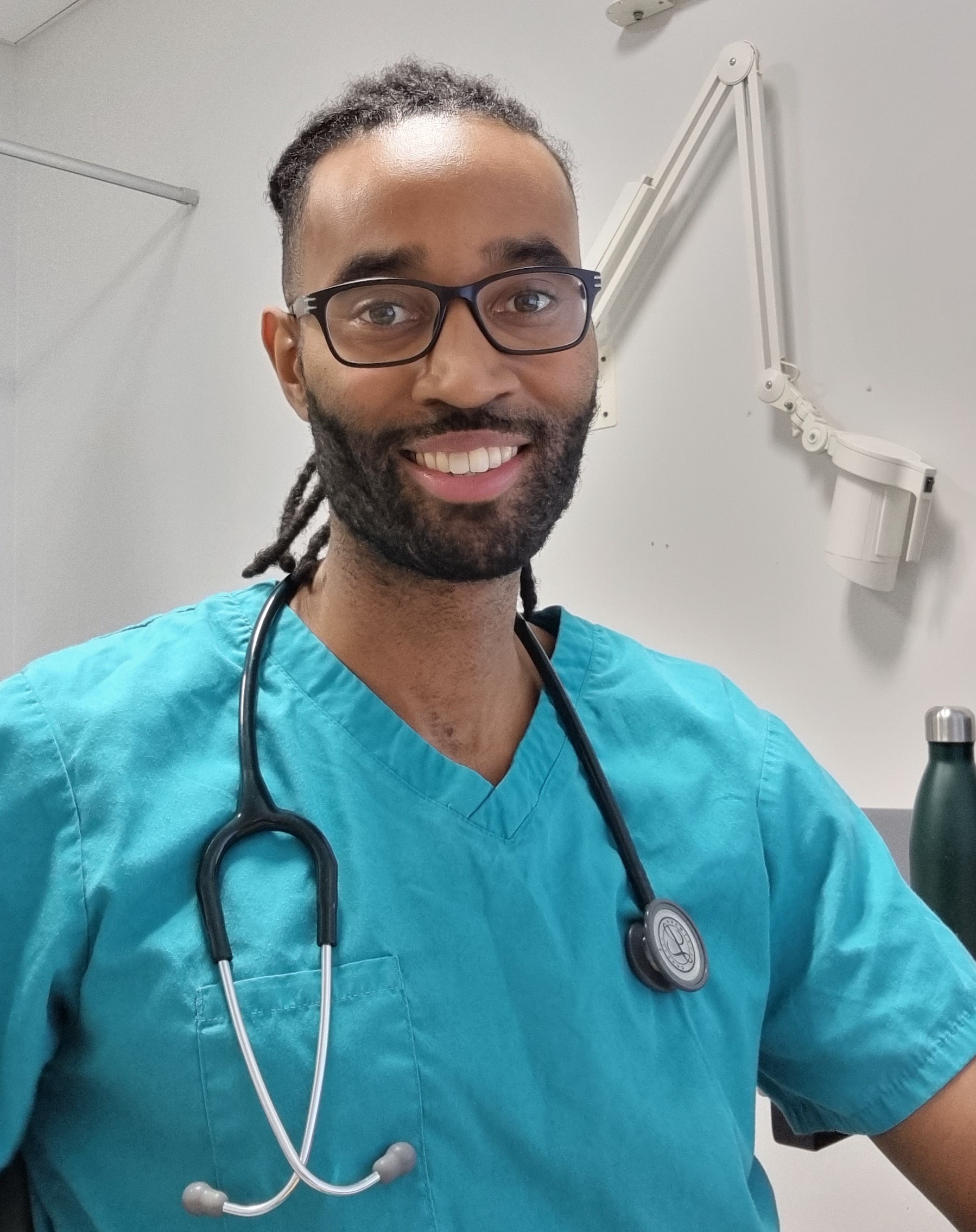 Dr Lewis Thomas, GP and sickle cell educator, smiling in clinical setting