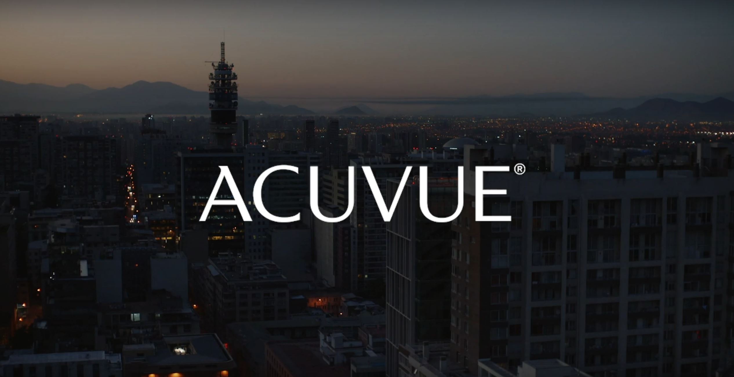City skyline at dusk with ACUVUE brand name overlayed in white text.