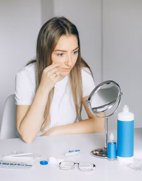 Woman checking her eye in the mirror