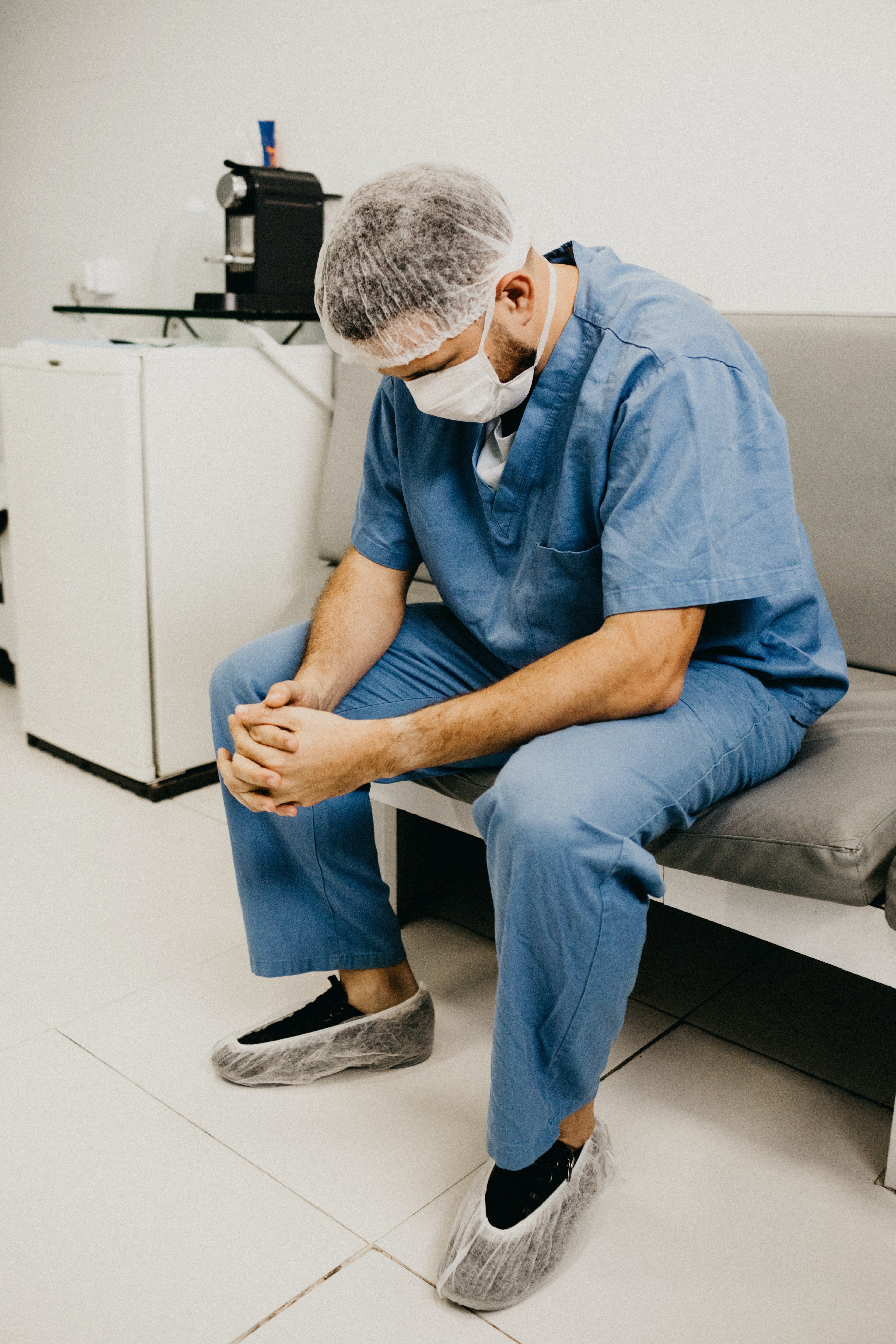 Un infirmier épuisé dans un hopital subissant les conséquences et les couts de l'absentéisme de son personnel