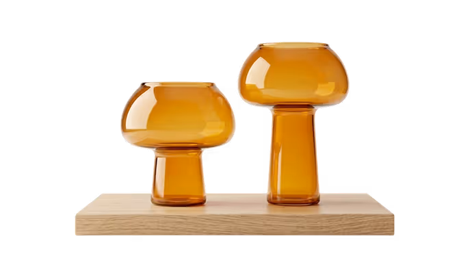 Two amber-colored glass mushroom-shaped vases of different heights placed on a wooden plank.
