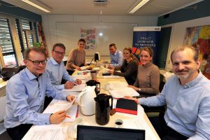 Smilende repræsentanter fra DEM og Region Midt om et mødebord