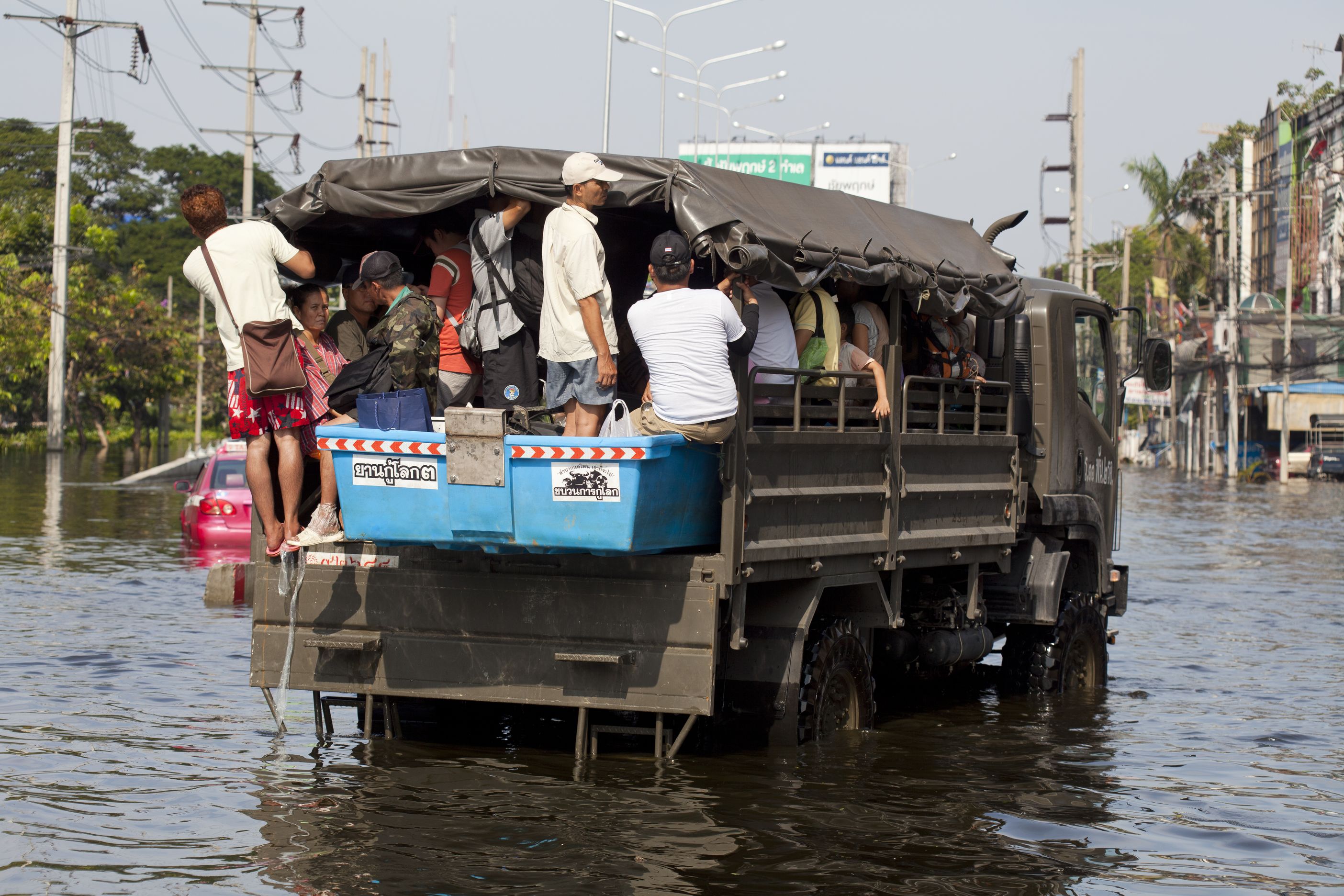 Car full of people crossing water in Jarkarta