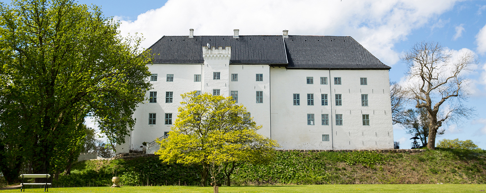 Hvidt slot i grønne omgivelser